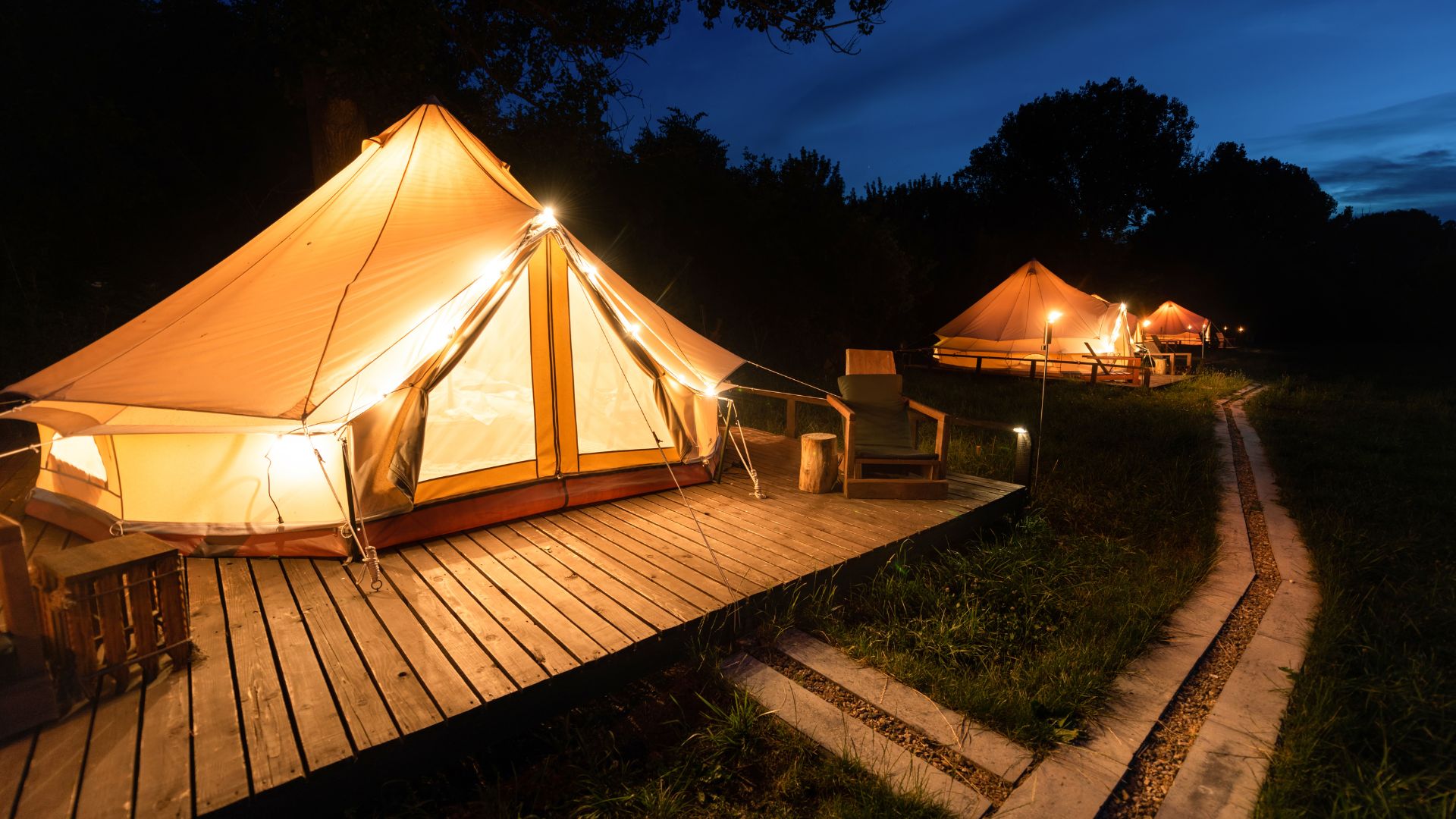 Glamping iluminado al atardecer sobre una plataforma de madera
